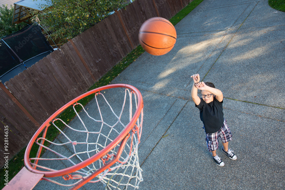 Naklejka premium Young boy playing basketball