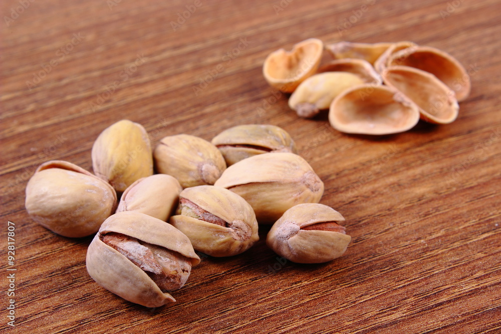 Pistachio nuts with shells on wooden table, healthy eating Pistachio nuts with shells on wooden table, healthy eating