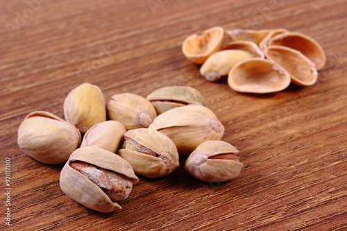Pistachio nuts with shells on wooden table, healthy eating