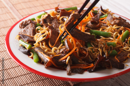 Lo mein noodles with beef and black fungus macro on a plate. Horizontal
 photo