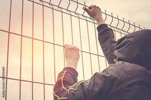 Refugee men and metal fence. photo