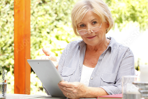 Senor woman with diigital tablet photo