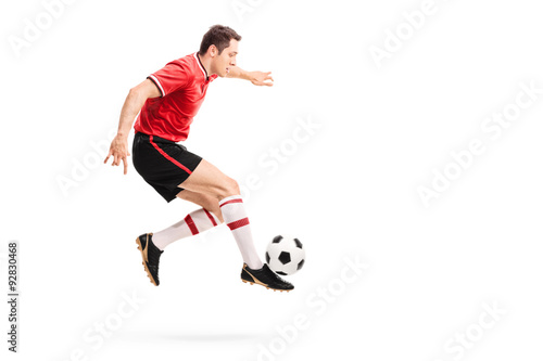 Young athlete jumping and kicking a football © Ljupco Smokovski