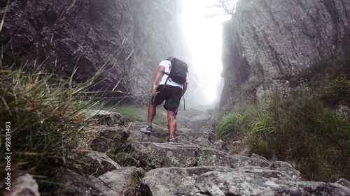 Man with backpacking hiking on the Platteklip Gorge trail on Table Mountain in Cape Town, South Africa 