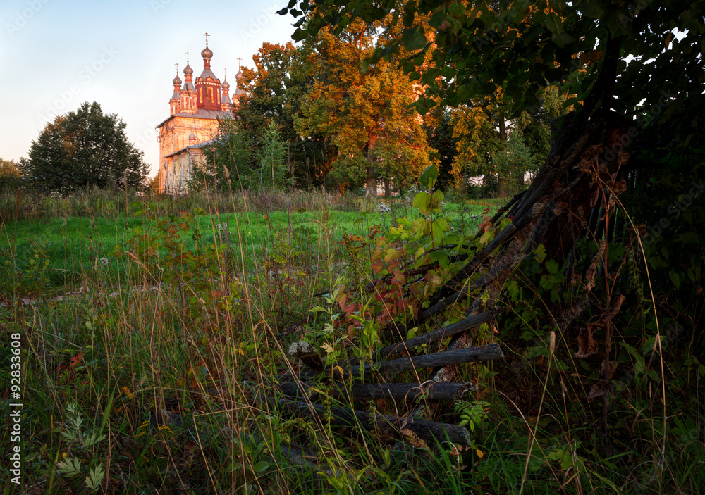 Rural landscape with old a fence in the foreground and church in the distance