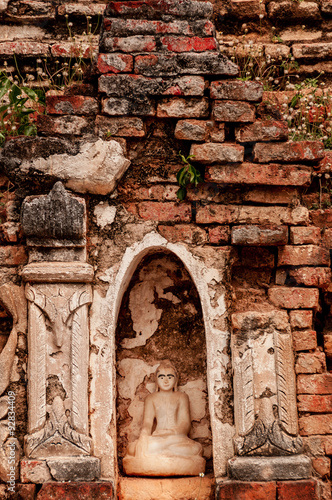 Sitting Buddha encarved in stone with bricks photo