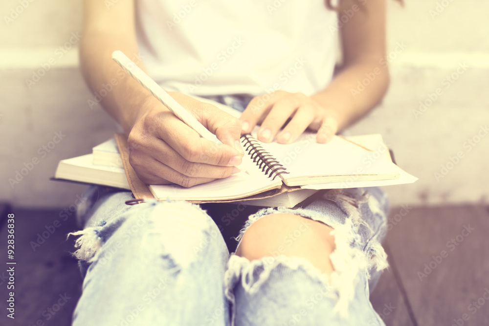 Naklejka premium Girl sitting on floor and wrote in a diary