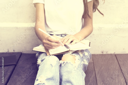 Schoolgirl sitting on floor and wrote in a diary