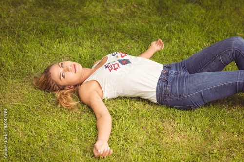 High angle portrait of smiling woman lying on grass 