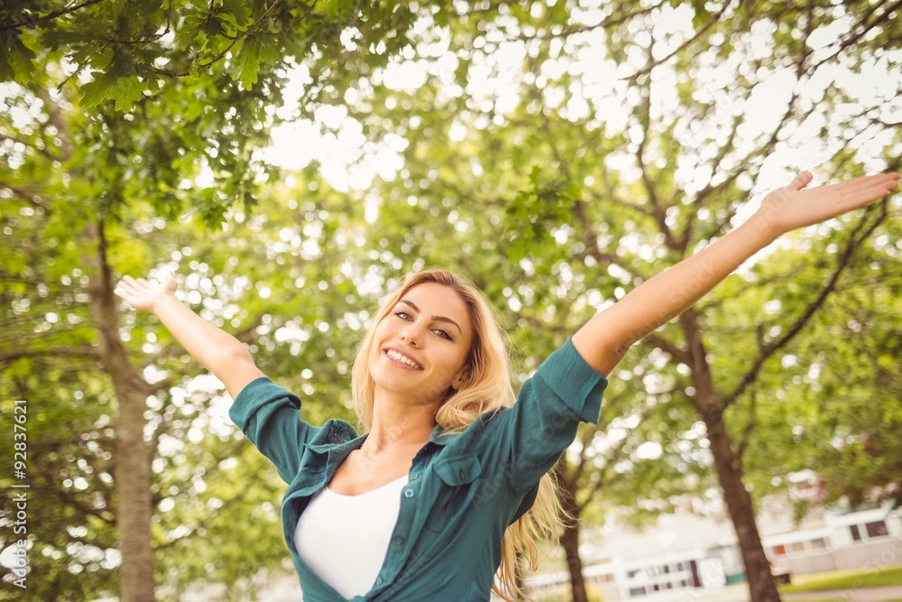 Portrait of beautiful woman with arms raised at park Portrait of beautiful woman with arms raised at park
