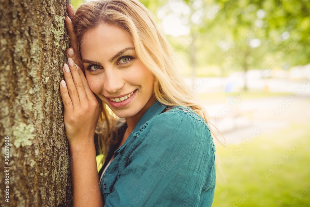Portrait of beautiful smiling woman touching tree Portrait of beautiful smiling woman touching tree