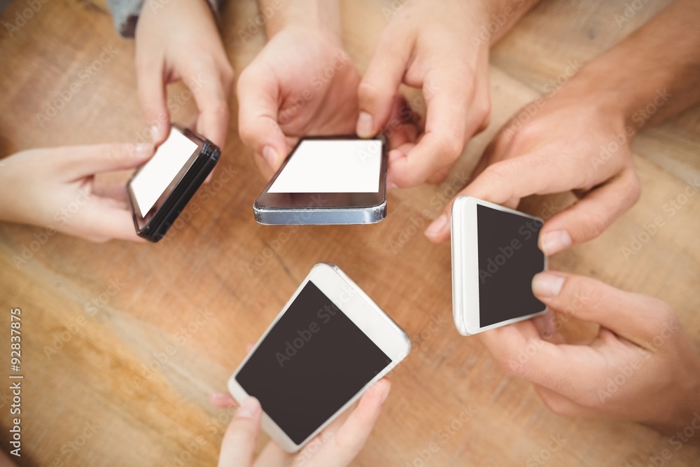 Overhead view of cropped hands using smartphones Overhead view of cropped hands using smartphones