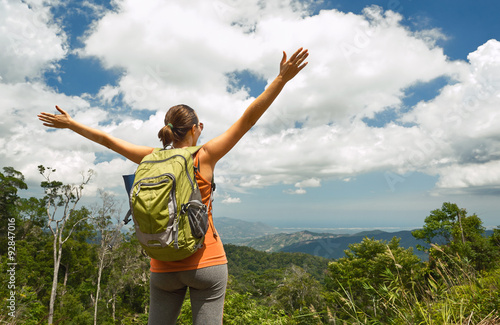 Woman traveler with backpack enjoying mountains view