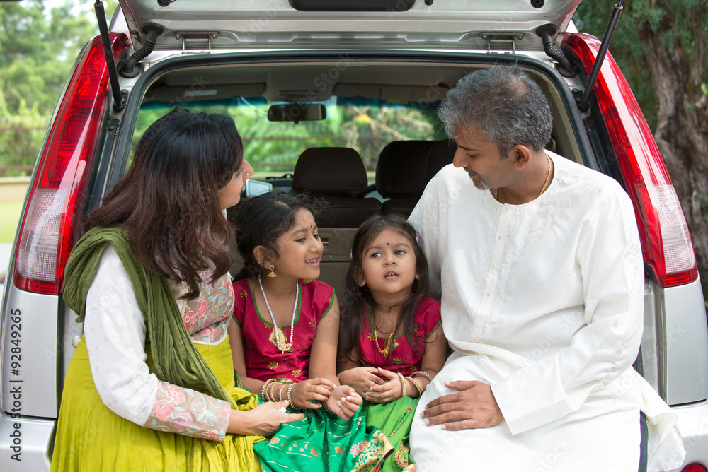 Happy Asian Indian family sitting in car talking and smiling hap