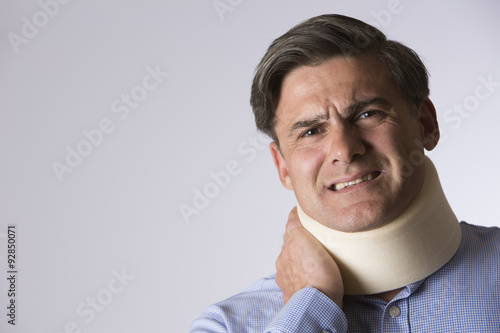 Studio Shot Of Masn In pain Wearing Neck Brace photo