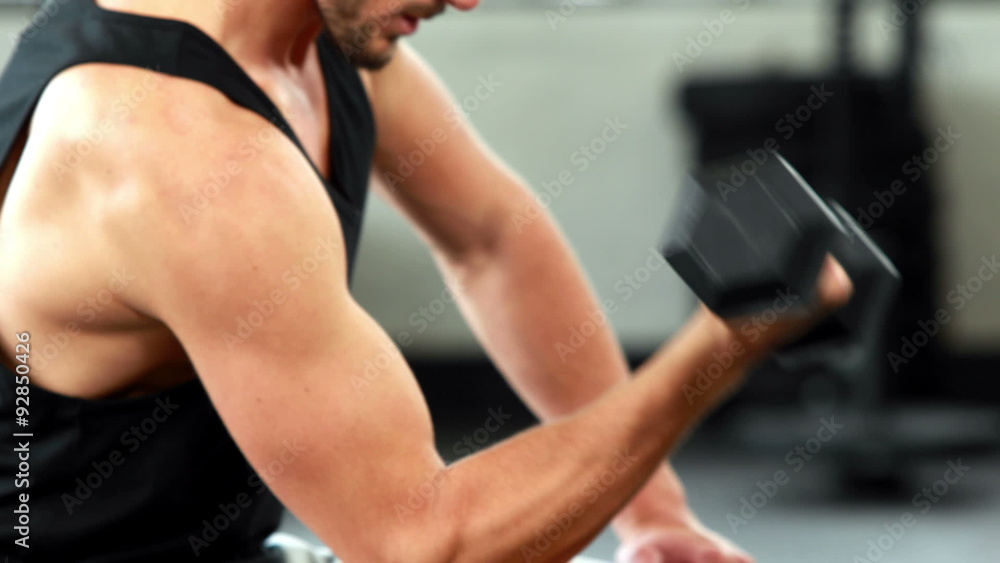 Fit man lifting heavy black dumbbell Fit man lifting heavy black dumbbell