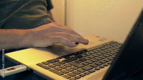 Close up of a hand typing on laptop keyboard at home