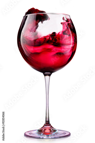 Glass of red wine with splashes isolated on a white 