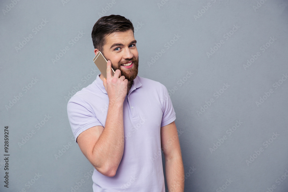 Casual man talking on the phone and looking at camera Casual man talking on the phone and looking at camera