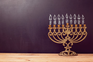 Jewish holiday Hanukkah background with menorah over chalkboard with hand drawing