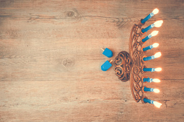 Jewish holiday Hanukkah creative background with menorah. View from above with focus on menorah. Retro filter effect.