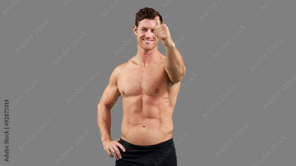 Muscular man with thumbs up posing Muscular man with thumbs up posing