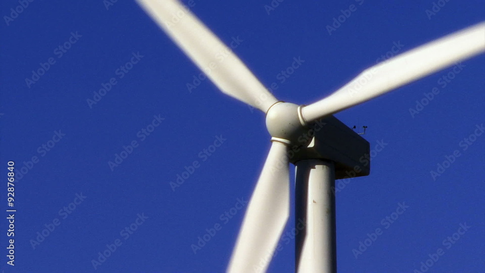 Wind Power 0104: Close up of a white wind energy turbine turning against a clear blue sky. Wind Power 0104: Close up of a white wind energy turbine turning against a clear blue sky.