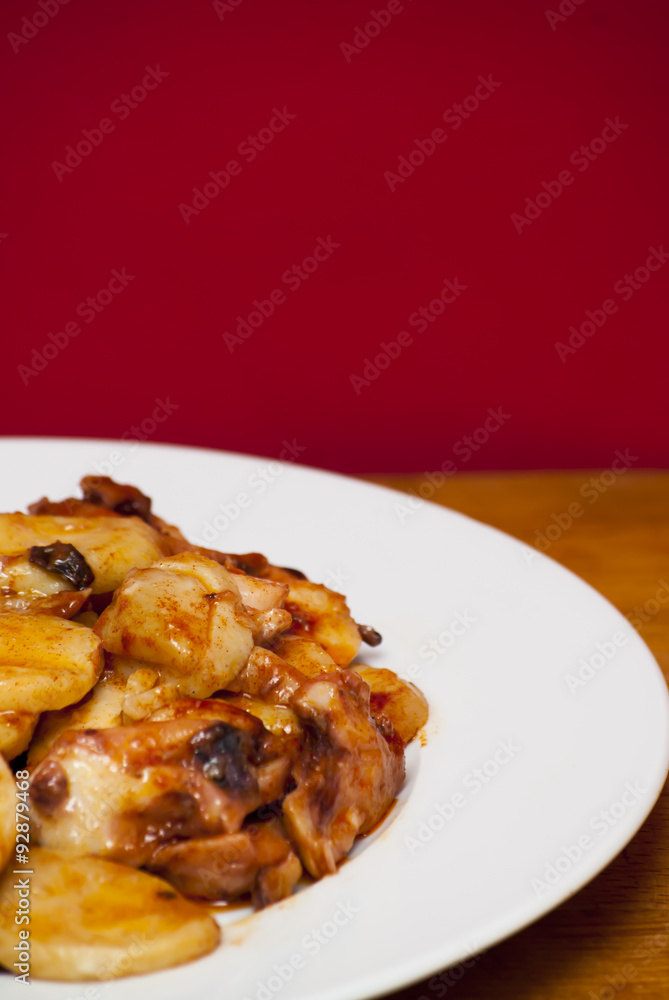 Octopus with paprika on a white plate, also known as Galician oc