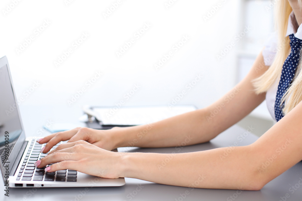 Fototapeta premium Close up of business woman hands typing on laptop computer, blue tie with polka dots
