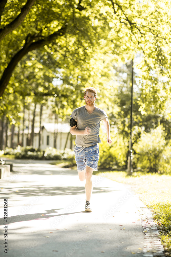 Young man running in the autumn park