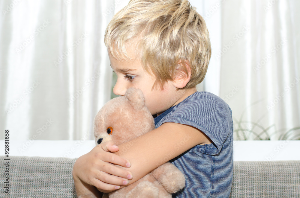 Junge kuschelt mit Teddy Junge kuschelt mit Teddy