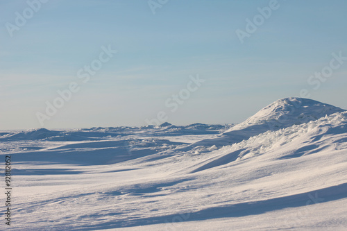 Snow desert and blue winter sky. Mountains on the horizon © larineb