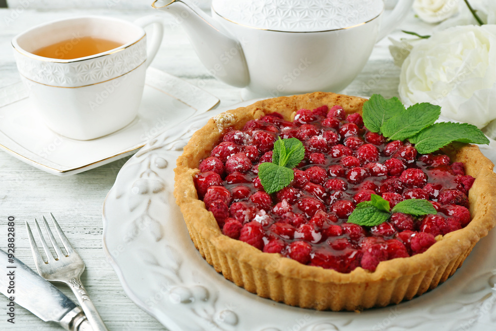 Tart with raspberries and tasty tea, on color wooden background Tart with raspberries and tasty tea, on color wooden background