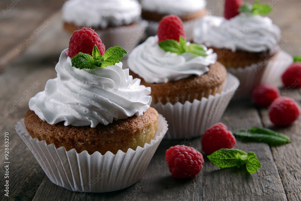 Delicious cupcakes with berries and fresh mint on wooden table close up