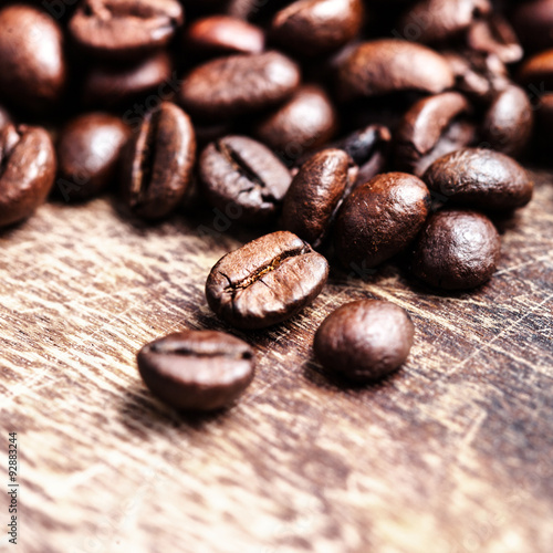 Coffee beans on grunge wooden table top view image, macro