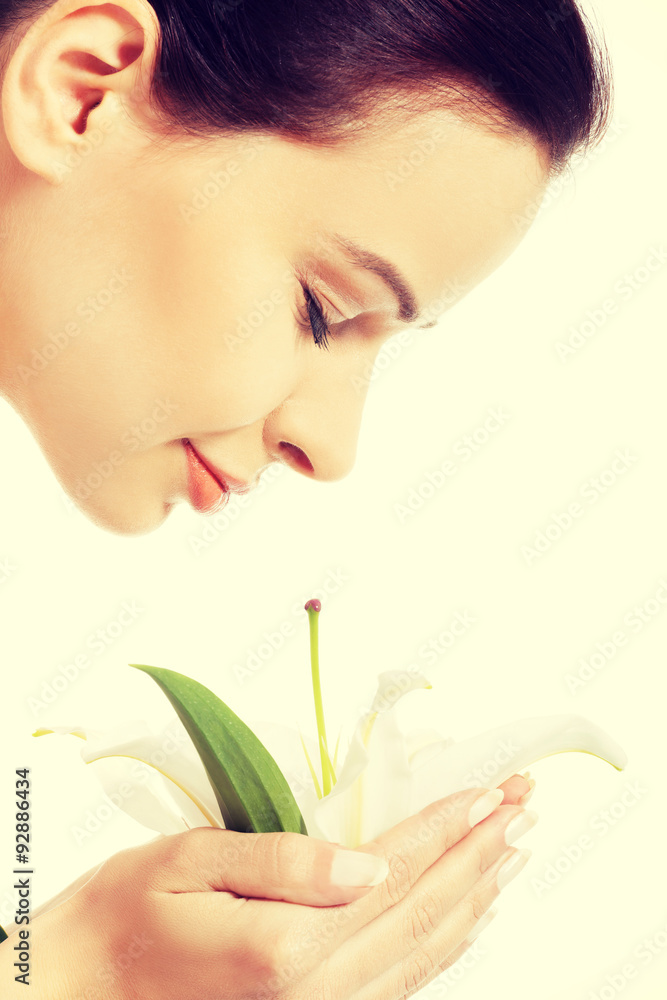 Young woman smelling white lily