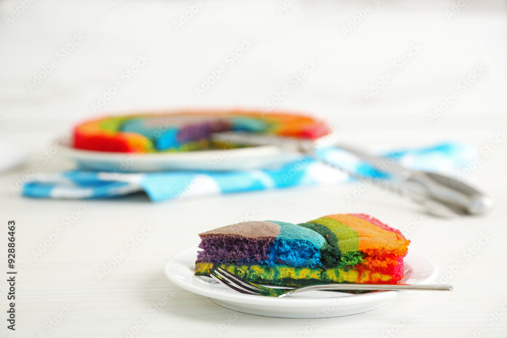 Delicious rainbow cake on plate, on light background Delicious rainbow cake on plate, on light background