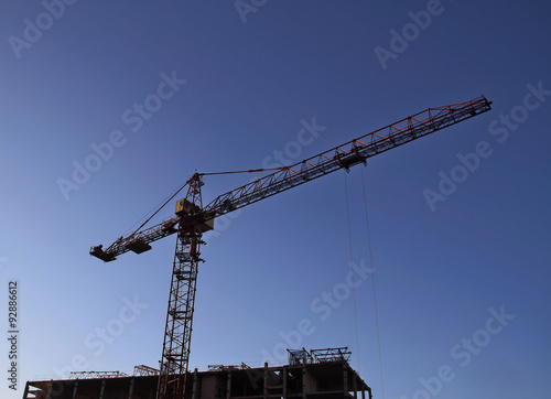Construction crane over concrete frame of high rise building 