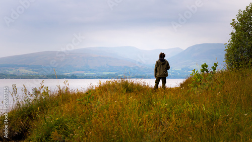 Hipster man standing by Loch Lomond, Scotland, UK © andreaobzerova