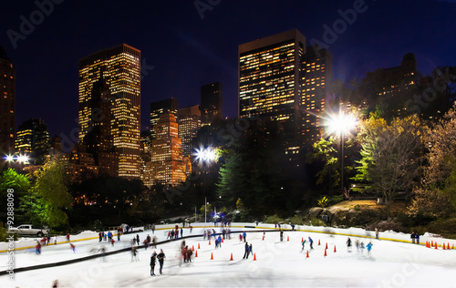 New York City ice rink at night surrounded by skyscrapers