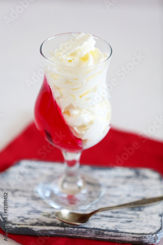 Tasty Jelly desserts with cream on light background