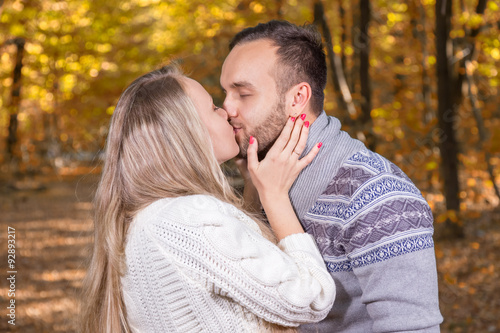 Young couple in love looking at each other in autumn park vintage stylized