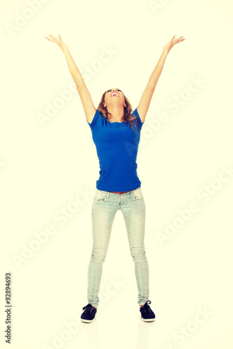 Young woman with arms raised.