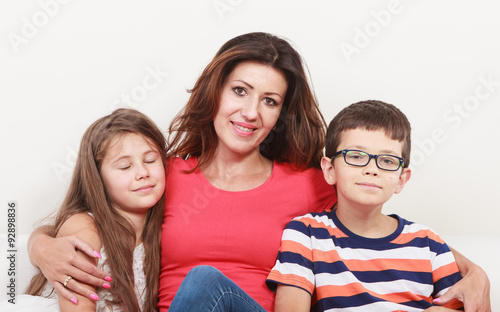 Happy family. Mother and kids on sofa at home.