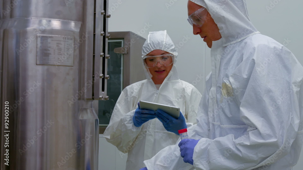 Scientists in protective suits working together Scientists in protective suits working together
