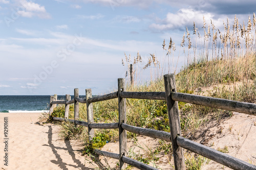 Wooden Fence on sandy pathway to beach grass and dunes at Sandbridge Beach in Virginia Beach, Virginia. 