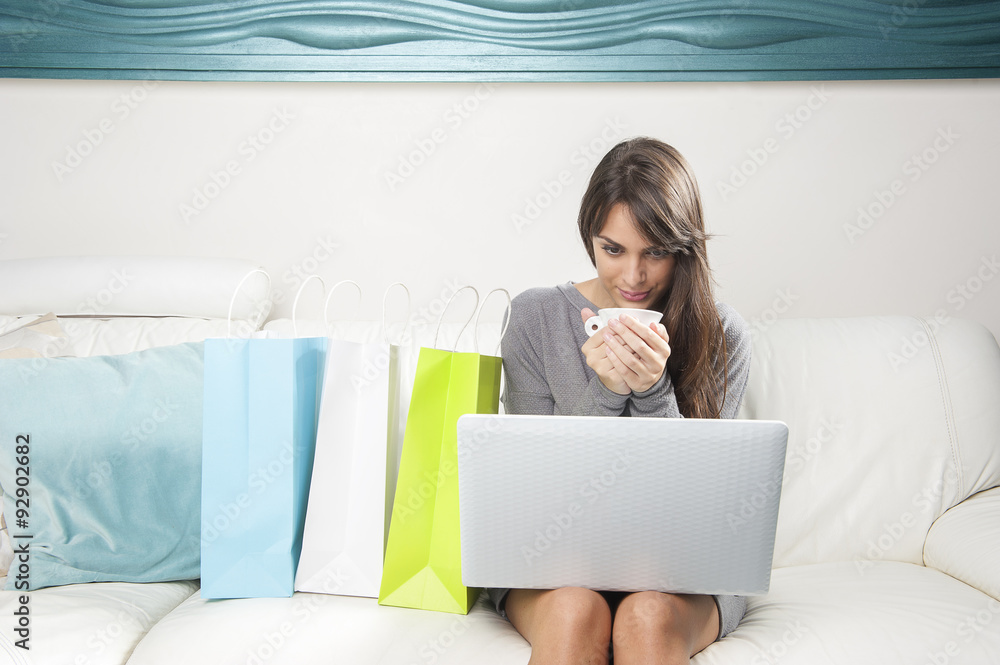 Woman  holding her cup and uses her laptop
