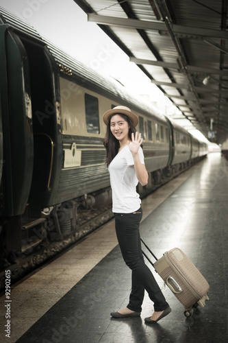 Shot of a beautiful young Asian woman traveling pulling a luggag photo