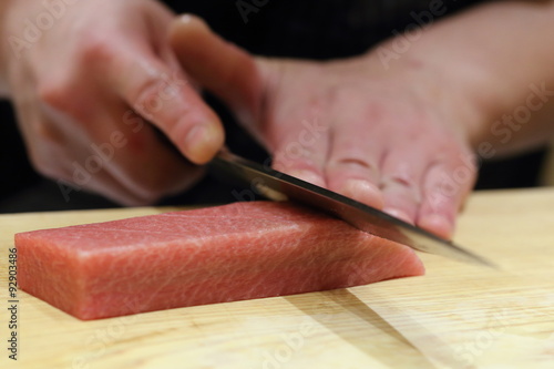 hand of japanses sushi chef slice a sashimi