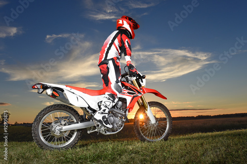 Fototapeta Naklejka Na Ścianę i Meble -  Motocross Byker Riding During Sunset